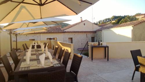 a table with chairs and an umbrella on a patio at Abas Ristorante Pizzeria Affittacamere in Ales