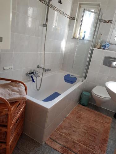 a bathroom with a tub and a toilet and a sink at Ferienwohnung Niklas in Völklingen