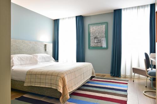 a bedroom with a bed and a table and chairs at The Editory House Ribeira Porto Hotel in Porto