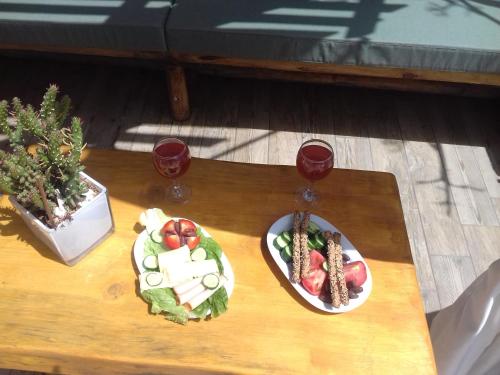 a table with two plates of food and two glasses of wine at Villa Aeolus with private overflow, endless, heated pool in Prinés