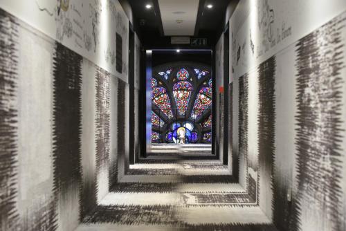 a hallway with a stained glass window in a church at Martin's Dream Hotel in Mons
