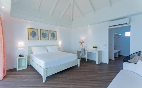 a white bedroom with a bed and a couch at Sandies Bathala in Bathala