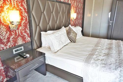 a bedroom with a bed with a headboard and a table at Svalinn Hotel in Izmir