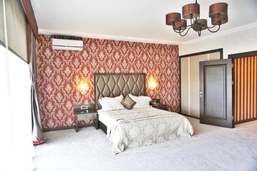 a bedroom with a large bed and red wallpaper at Svalinn Hotel in Izmir