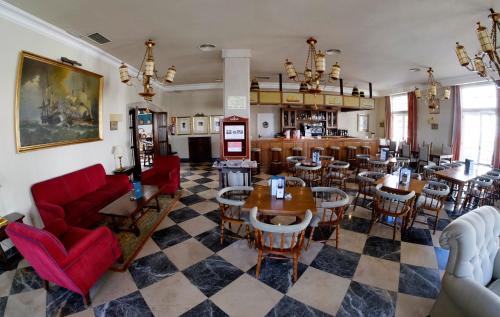 a living room with tables and chairs and a restaurant at Parador de Ferrol in Ferrol