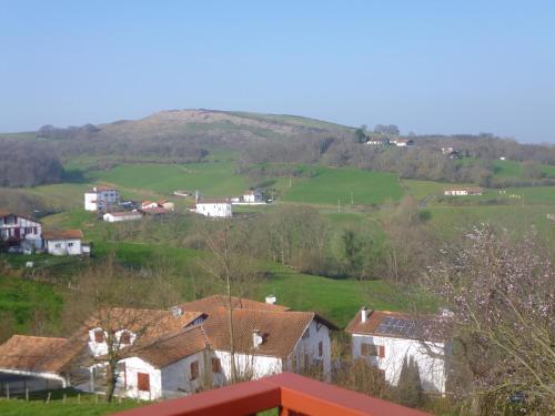 a view of a village with a hill in the background at Appartement au coeur du pays basque : vue superbe in Saint-Esteben