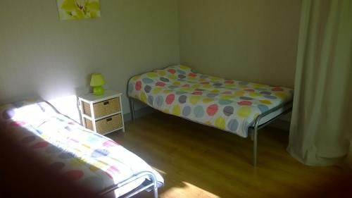 a small bedroom with two beds and a night stand at Appartement au coeur du pays basque : vue superbe in Saint-Esteben
