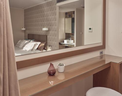 - une chambre avec un grand miroir et un lit dans l'établissement Golden Sun Resort - Adults Only, à Kalamaki