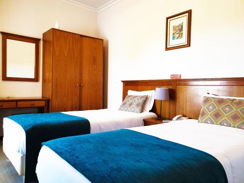a hotel room with two beds with blue sheets at Ninho do Falcao in Sao Pedro de Tomar