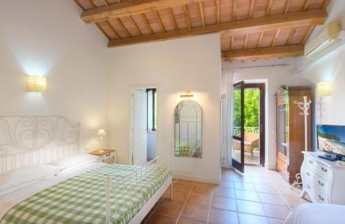 a bedroom with a bed with a green and white blanket at Borgo Rosso Country House B&B in Sirolo