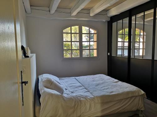 une chambre avec un lit et deux fenêtres dans l'établissement Villa Fleur des Pins 14 personnes 3 étoiles Bassin Arcachon, à Gujan-Mestras