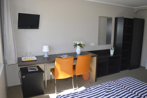 a room with a desk with chairs and a bed at Haus Störtebeker in Ahlbeck