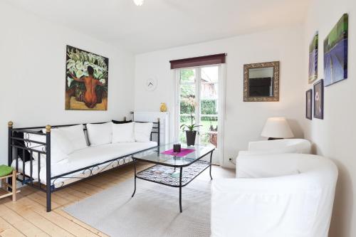 a living room with a white couch and a table at FeWo Katharina (Teestube Undeloh) Lüneburger Heide in Undeloh