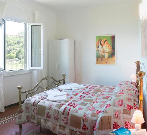 una camera da letto con un letto con una coperta e una finestra di Gli ulivi sul Golfo e le 5 terre a La Spezia