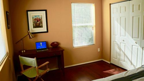 a bedroom with a desk with a laptop computer on it at Beautiful Hollywood style home next to Disney in Kissimmee