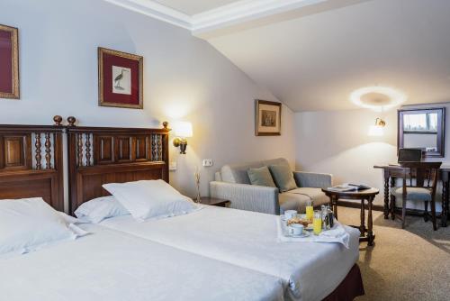 a hotel room with a bed and a couch at Parador de Ferrol in Ferrol