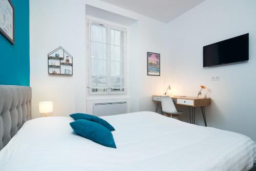 - une chambre avec un lit, un bureau et une télévision dans l'établissement Le Bleu Nantais, à Nantes