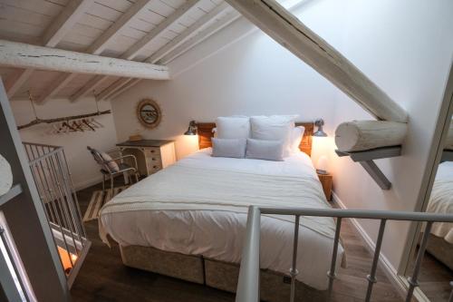 1 dormitorio con 1 cama blanca en el ático en Demeure Terrisse La Maison, en Marseillan