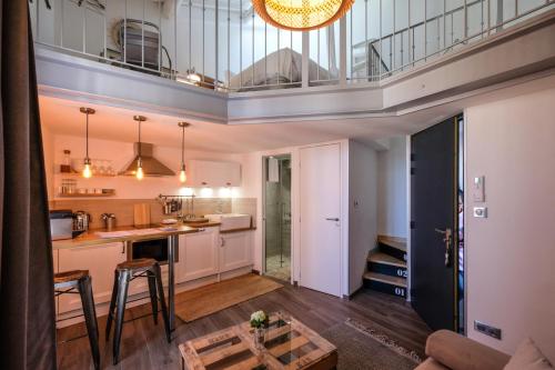 a kitchen and living room with a balcony at Demeure Terrisse La Maison in Marseillan