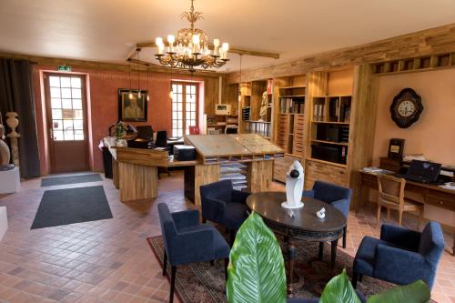 - un salon avec une table et des chaises dans l'établissement Domaine Utah Beach - Le Grand Hard, à Sainte-Marie-du-Mont