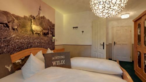 a bedroom with a bed and a chandelier at Boutique Hotel POST ANDECHS in Andechs