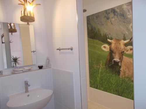a bathroom with a painting of a cow on the wall at Boutique-Hotel „Altes Rathaus“ in Lahnstein