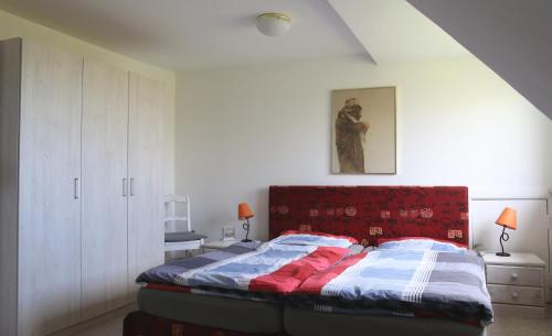 a bedroom with a bed with a red headboard at Ferienwohnung Süderdeich in Neukirchen