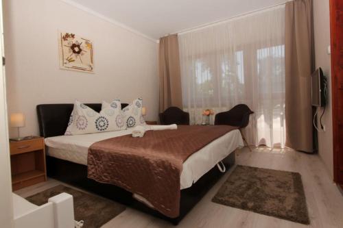 um quarto com uma cama grande e uma janela em Ariel apartmanok em Siófok