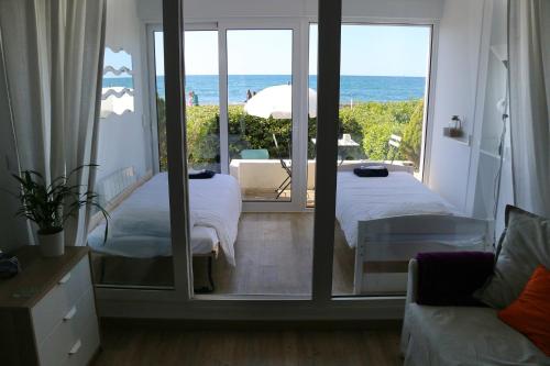 een slaapkamer met 2 bedden en uitzicht op de oceaan bij Hendaye Beach Studio, front de mer avec parking privé in Hendaye