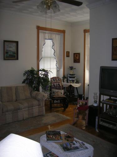 a living room with a couch and a tv at Historic Hill Inn in Newport