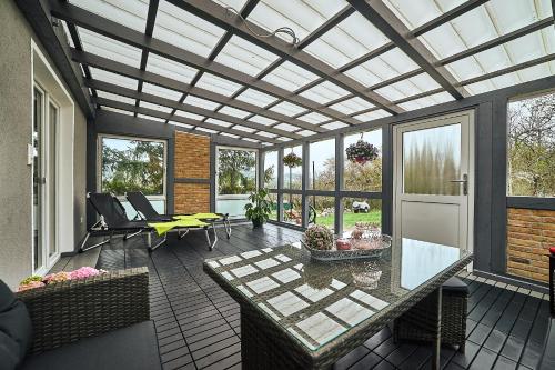 a screened in porch with a glass table and chairs at Bagger's Ferienhaus in Timmenrode