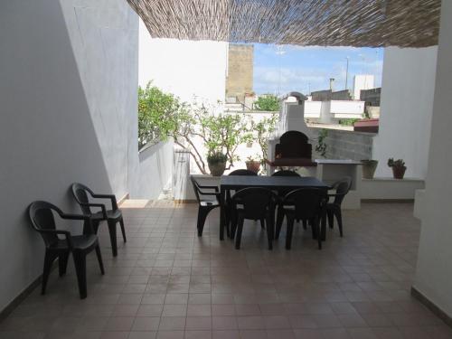 a dining room with a table and chairs on a balcony at Maison Gigante in San Donato di Lecce