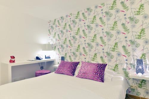a bedroom with a bed with a floral wallpaper at Hotel Durbuy Ô in Durbuy