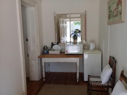 a kitchen with a table with a mirror and a sink at Die Hoekhuis in Cradock