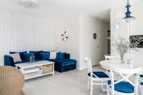 a living room with a blue couch and a table at Lion Apartments - Blue Marina Premium Apartment Okrzei 21 in Sopot