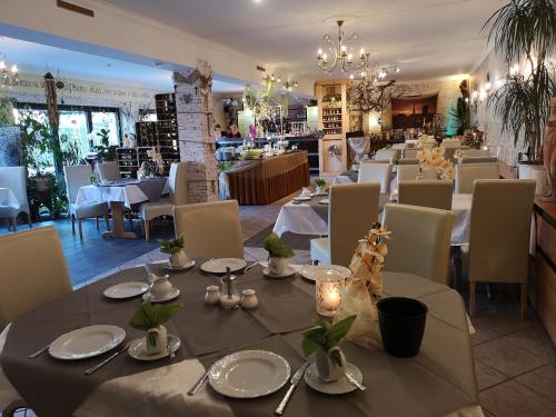 een eetkamer met witte tafels en stoelen bij Altstadt Pension Orchidee in Wernigerode