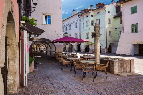 an empty street with tables and chairs and buildings at Albergo Diffuso ELA Living - Apartment Bellepoque in Egna