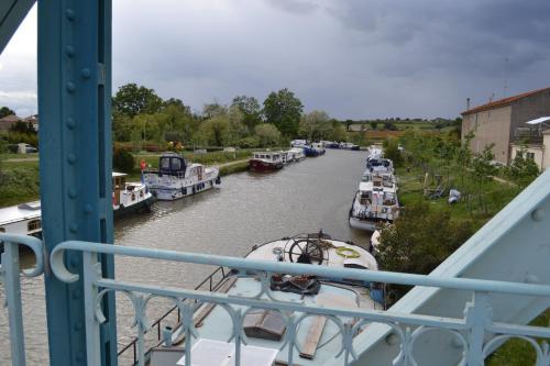 a group of boats are docked on a river at L'instant Canal in Capestang
