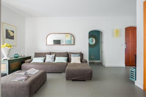 a living room with a couch and a ottoman at La Matrangela Charme Apartments in Taormina
