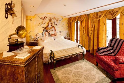 a bedroom with a bed, a chair, and a painting on the wall at Ikala Quito Hotel in Quito
