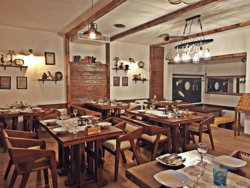 comedor con mesas y sillas de madera en Etno Garden Apartments en Plitvica selo