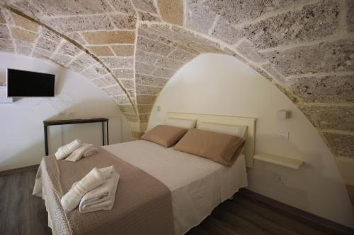 a bedroom with a bed with a stone wall at VILLA ROSA in Torre Suda