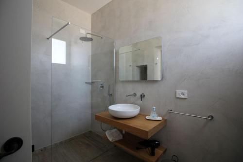 a bathroom with a sink and a glass shower at VILLA ROSA in Torre Suda