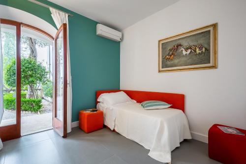 a bedroom with a bed and a table and a window at La Matrangela Charme Apartments in Taormina