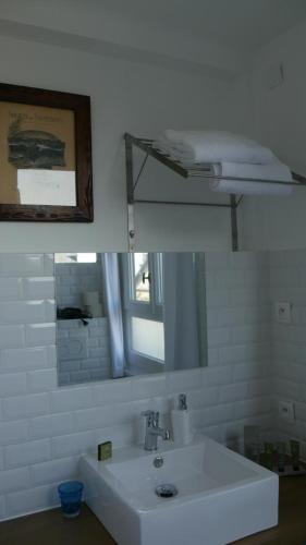 une salle de bain blanche avec un lavabo et un miroir dans l'établissement La Moussette, à Honfleur