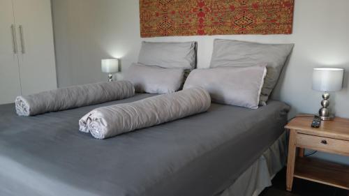 uma cama com duas almofadas em cima em Panorama Indlu em Cidade do Cabo