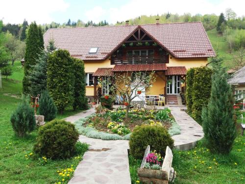 a house with a garden in front of it at Casa Lucia in Dămuc