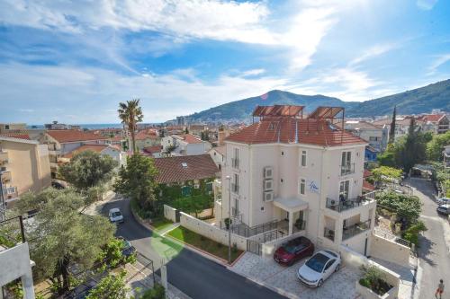 a building in a city with a mountain in the background at Apartment L Palace in Budva
