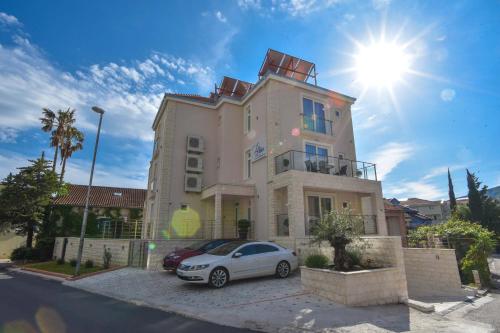 a white car parked in front of a building at Apartment L Palace in Budva