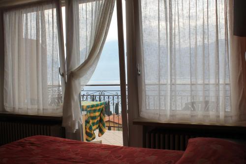 a bedroom with a bed and a window with a view at Hotel Casa Gagliardi in Brenzone sul Garda